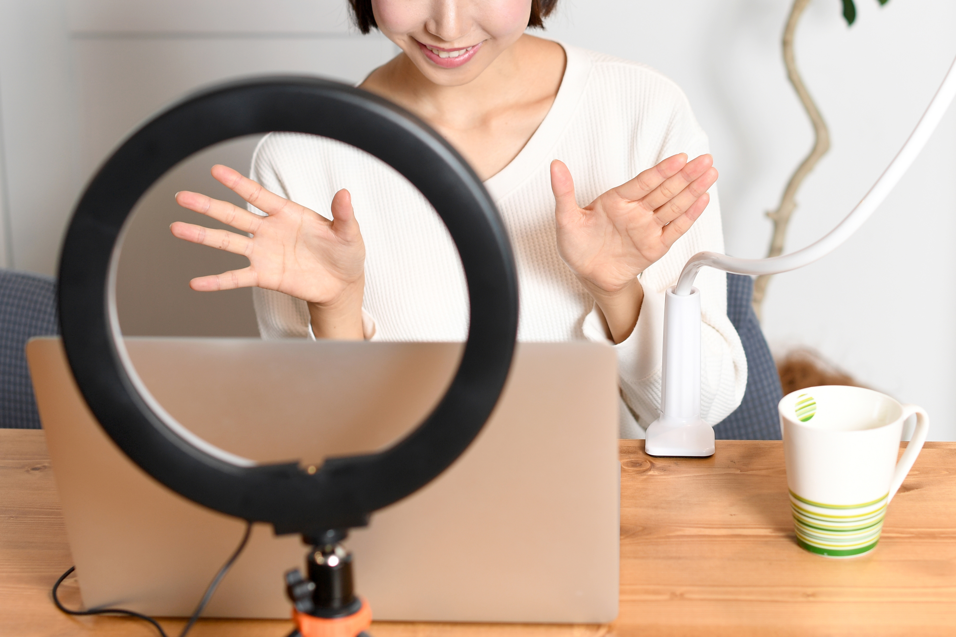 笑顔でライブ配信する若い女性（配信者）